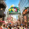 The colourful Takeshita Street entrance above a busy shopping street in Harajuku, Tokyo.