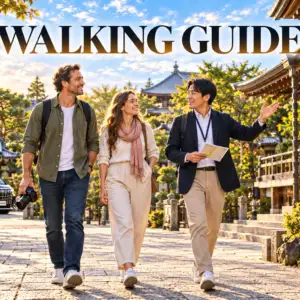 A private walking guide explaining Japanese temple sights to two guests, with a Toyota Alphard in the background.